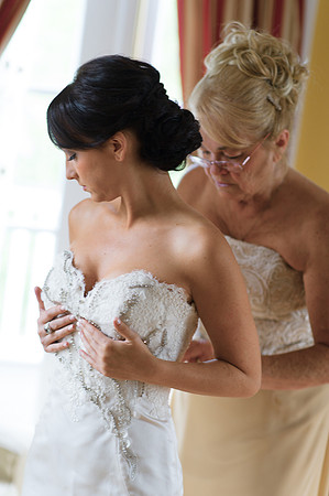 Bride Getting into Wedding Dress with Mother