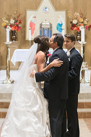Father Kisses Bride at Alter